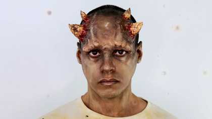 film still from Adham Faramawy Skin Flick 2019, showing a person with horns looking at the camera and