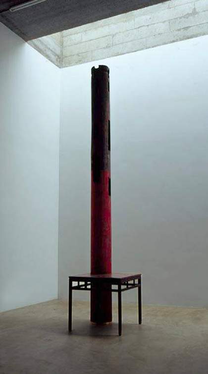 A metal pillar stands inside a metal table