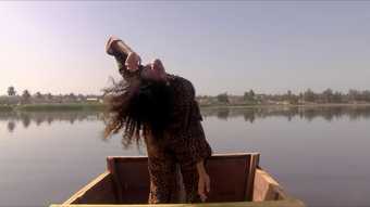 a person stands in a small boat on a lake