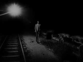 photograph of a man walking along a railway track at night
