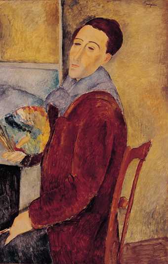 Modigliani sits in a chair holding a palette