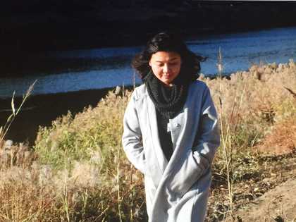 Photography of artist Tao Aimin walking in a rural landscape
