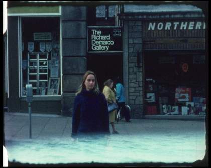 image of a woman standing in front of a few shops