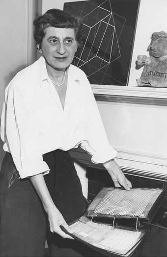 Anni Albers with textile samples in her home in New Haven, c.1950–60, photographed for the New Haven Register - Courtesy the Josef and Anni Albers Foundation