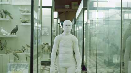 a film still of someone bandaged like a mummy