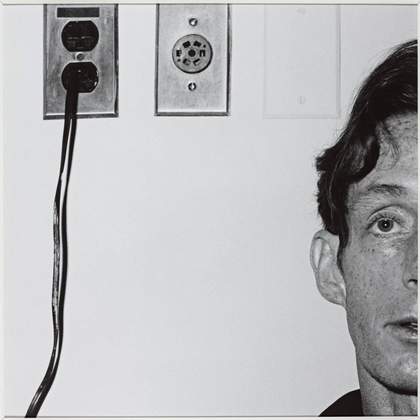 a man stands in front of two plug sockets
