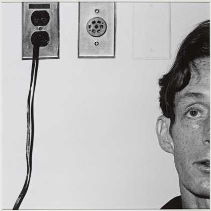 a man stands in front of two plug sockets