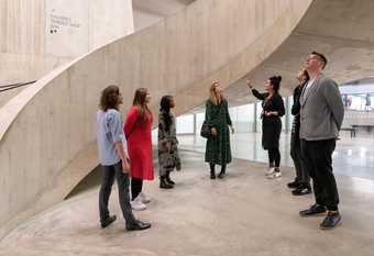 people stand in the Tanks in Tate Modern and look up at the spiral staircase