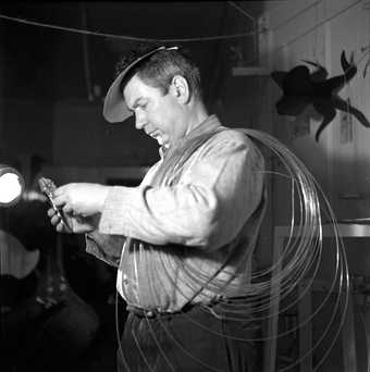 Herbert Matter, Alexander Calder in his studio, with wire