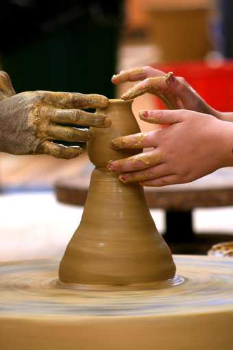 Image of hands on a pottery wheel