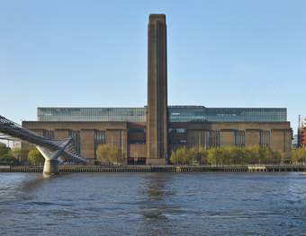 A large building with a chimney in front of the River Thames