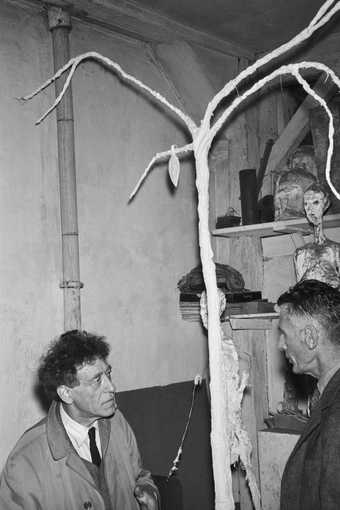 A black and white photograph of Beckett and Giacometti with a plaster tree designed by Giacometti 