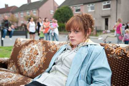 Clio Barnard The Arbor 2010 video still of a redheaded teenage girl sitting on a sofa outside