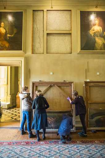 Curators inspect one of Michael Dahl’s paintings in the Beauty Room at Petworth House, West Sussex