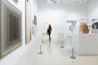 a series of wire barriers are around sculptures and paintings in the gallery