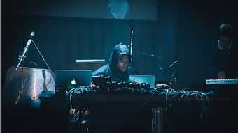 Man performing electronic music in the dark