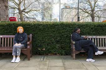 Two people sat on benches outside