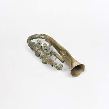 Photograph of a silver damaged horn on a white background