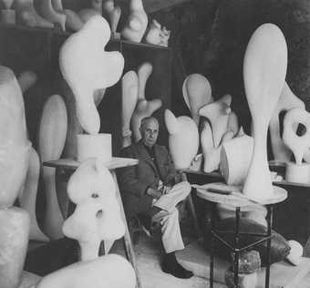 Jean (Hans) Arp surrounded by his biomorphic sculptures in his studio at Meudon, near Paris, 1958, photographed by André Villers