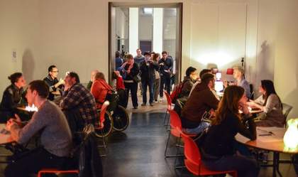 A number of people discuss around tables