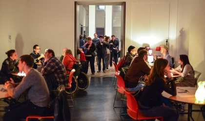 A number of people discuss around tables