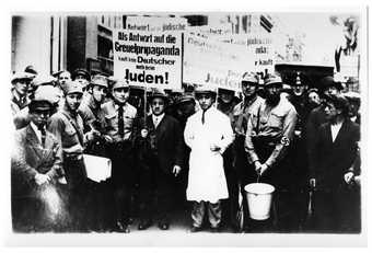 Arnold Katz and his son Benno Katz being paraded through Cologne during a boycott of Jewish businesses on 1 April 1933