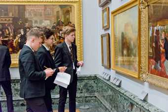 Image shows some school boys looking at art in Tate Britain