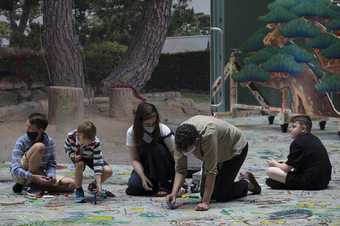 Families draw on the floor in the turbine hall at Tate modern