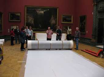 Team of Art Handlers, Conservators and Technicians preparing to unroll the canvas at Tate Britain. 