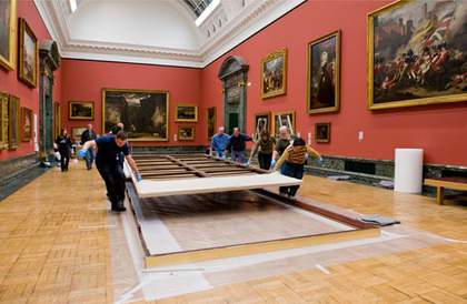 Manoeuvring the work to its frame for re-framing. 