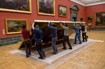 Carefully raising the work on its frame; installing work at Tate Britain