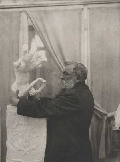 Rodin placing the plaster Clenched Hand with Imploring Figure on a pedestal, in the Pavillon de l’Alma, Meudon 1906. Photo by unknown photographer, Musée Rodin