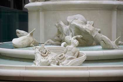 detail of fountain sculpture showing sharks lurking and a man in a a boat.