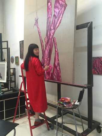 Artist Cai Jin working on a painting from her Banana Plant series in the studio