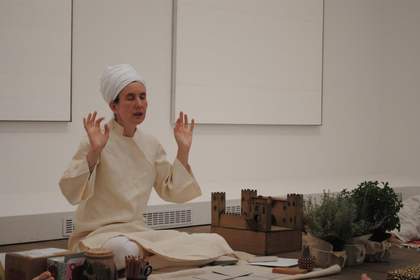 Close up of teacher sitting in yoga position on the floor of gallery