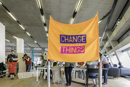 A large orange banner with the words ‘change things’ written on it