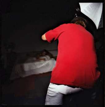 Chris Verene Untitled Red Back 1997 photograph of a man taking a picture of a woman posing on a bed