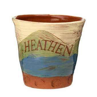 The word Heathen is carved against a backdrop of rolling hills, lakes and swooping birds on this handmade pot