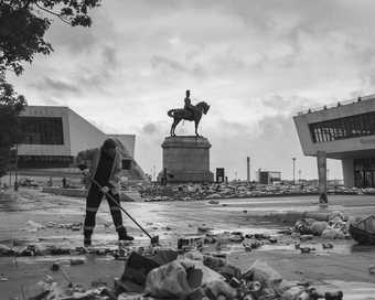  A cleaner sweeps an extremely messy scene at Liverpool docklands 
