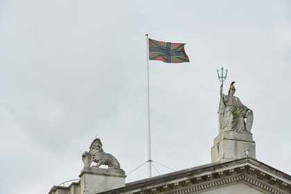 A black, green and red version of the union jack flag flying above Tate Britain