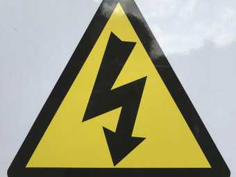 triangular electrical danger sign in yellow with a lightening bolt with an arrow at the end