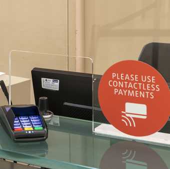 Card machine and a sign saying please use contactless payments.