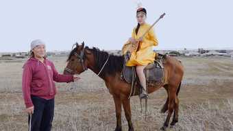 Film still of two people, one on a horse 