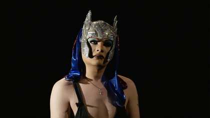 Film still of a woman in a headdress
