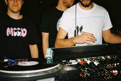 three young men behind the DJ deck