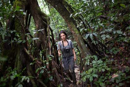 an image of Diana walking through a lush forest