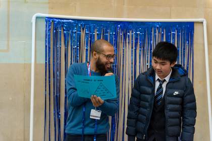 A child and workshop leader talk in front of a group