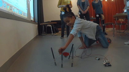 Kid playing with drawing robot