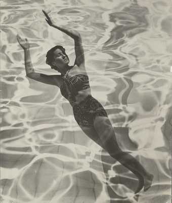 Black and white photograph of a women in a swimsuit with her arms in the air overlaid with the texture of water