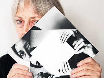 Dóra Maurer covers half her face with a mise-en-abime photograph of herself doing the same pose